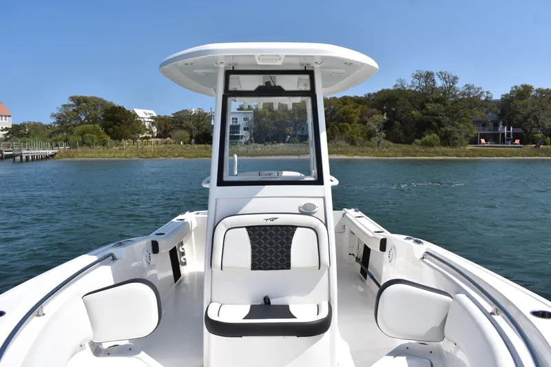Slide: The Image of 2023 Tidewater 232 CC Adventure boat on calm water, showcasing sleek design and spacious seating. - 9