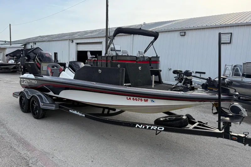 Slide: The Image of 2016 Nitro Z21 boat on trailer, parked outside a warehouse. - 13