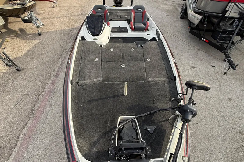 Slide: The Image of 2016 Nitro Z21 fishing boat with spacious deck and seating, parked on pavement. - 17