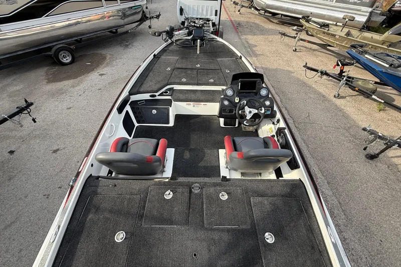 Slide: The Image of 2016 Nitro Z21 boat interior with dual seats and control panel, parked among other boats. - 22