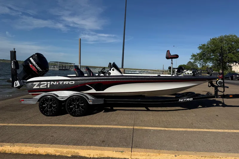 Slide: The Image of 2016 Nitro Z21 boat on trailer by the water, featuring Mercury engine. - 30