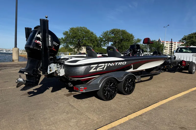 Slide: The Image of 2016 Nitro Z21 boat on trailer, parked near waterfront, featuring Mercury engine. - 33