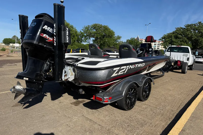 Slide: The Image of 2016 Nitro Z21 boat on trailer, featuring powerful Mercury engine, parked outdoors. - 34