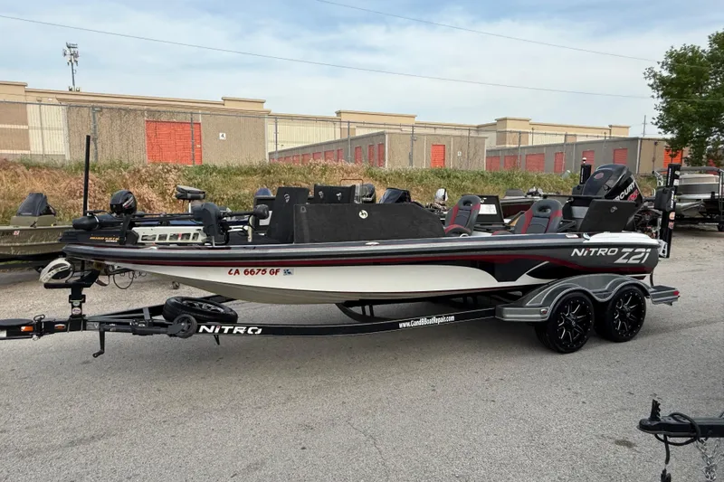 Slide: The Image of 2016 Nitro Z21 boat on trailer, parked outdoors near industrial buildings. - 4