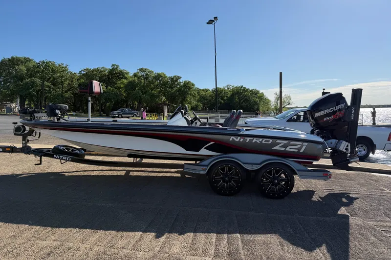 Slide: The Image of 2016 Nitro Z21 boat on trailer by lakeside, featuring Mercury Pro XS engine. - 48