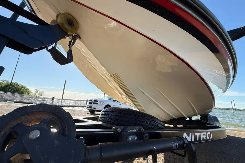 Slide: The Image of 2016 Nitro Z21 boat on trailer near a lake, showcasing hull design. - 54