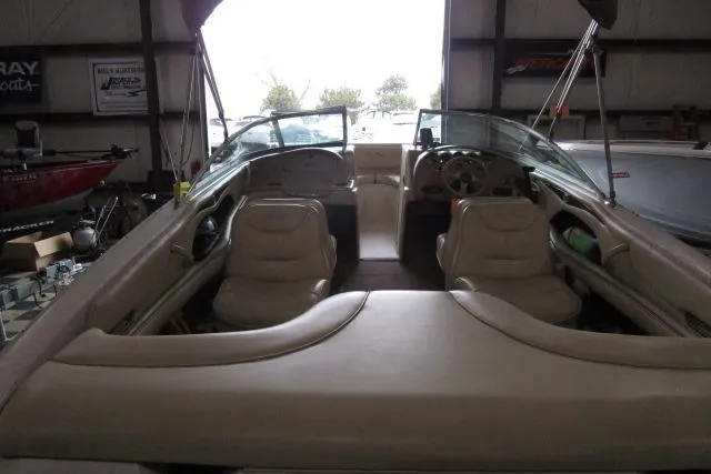 Slide: The Image of 2000 Sea Ray 210 Signature boat interior with dual seating and steering wheel in a garage. - 13