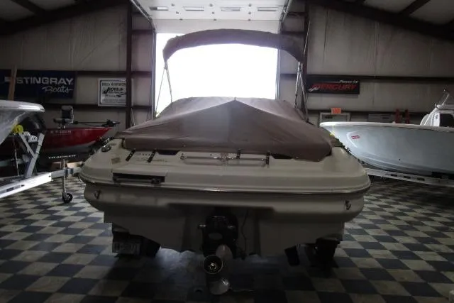 Slide: The Image of 2000 Sea Ray 210 Signature boat in indoor showroom, rear view with cover. - 15