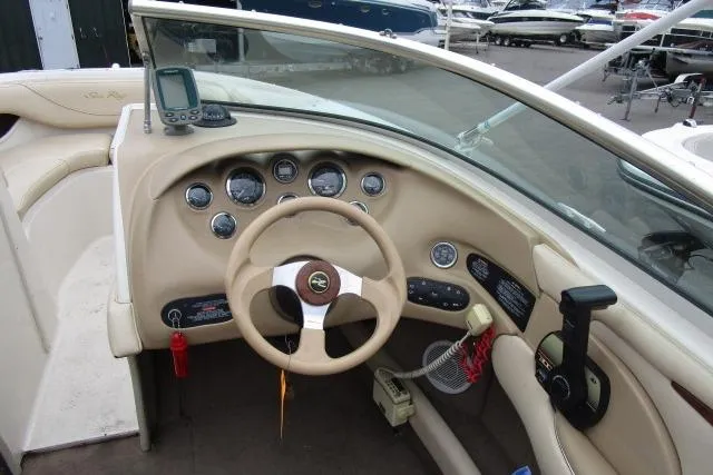 Slide: The Image of Interior view of a 2000 Sea Ray 210 Signature boat dashboard with steering wheel and controls. - 19