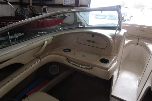 Slide: The Image of Interior of a 2000 Sea Ray 210 Signature boat, featuring beige seating and dashboard. - 5