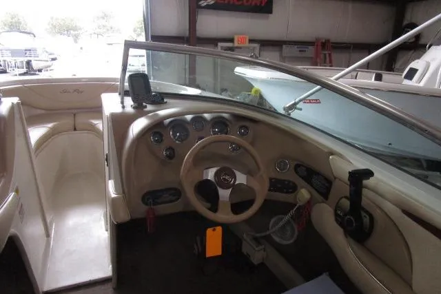Slide: The Image of Interior view of 2000 Sea Ray 210 Signature boat, featuring steering wheel and dashboard controls. - 6