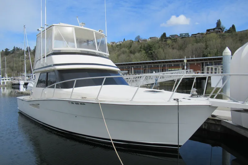 Slide: The Image of 1990 Viking 38 Convertible yacht docked at a marina, showcasing sleek design and spacious deck. - 1