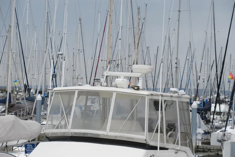 Slide: The Image of 1990 Viking 38 Convertible yacht docked among sailboats in a marina. - 12