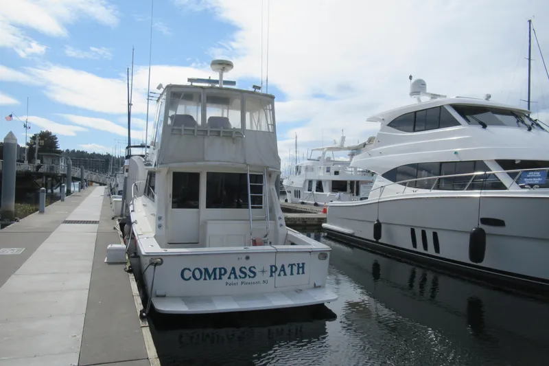 Slide: The Image of 1990 Viking 38 Convertible yacht docked at marina, labeled "Compass Path," Point Pleasant, NJ. - 2