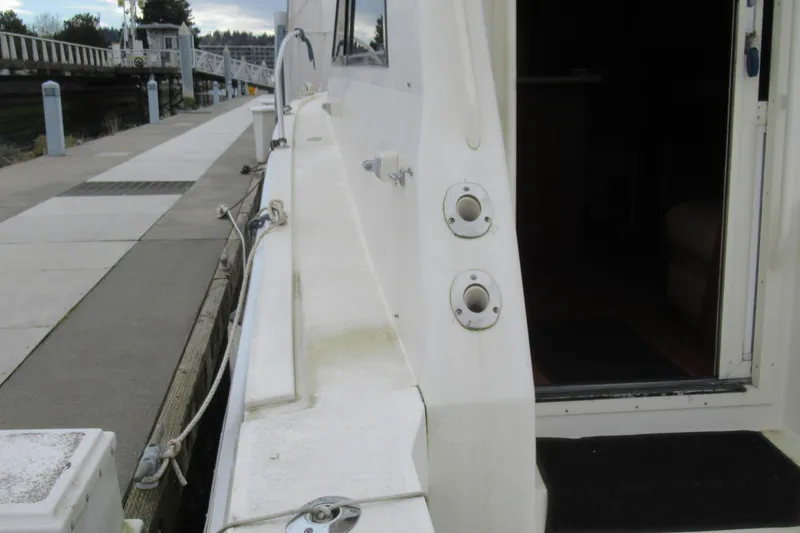 Slide: The Image of 1990 Viking 38 Convertible yacht docked, showing side view and open cabin door. - 23