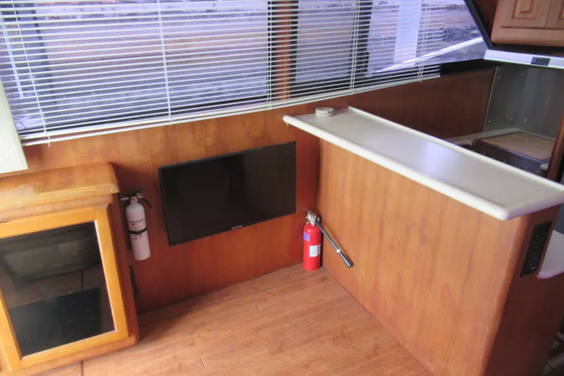 Slide: The Image of Interior of 1990 Viking 38 Convertible yacht with TV, fire extinguishers, and wooden cabinetry. - 30