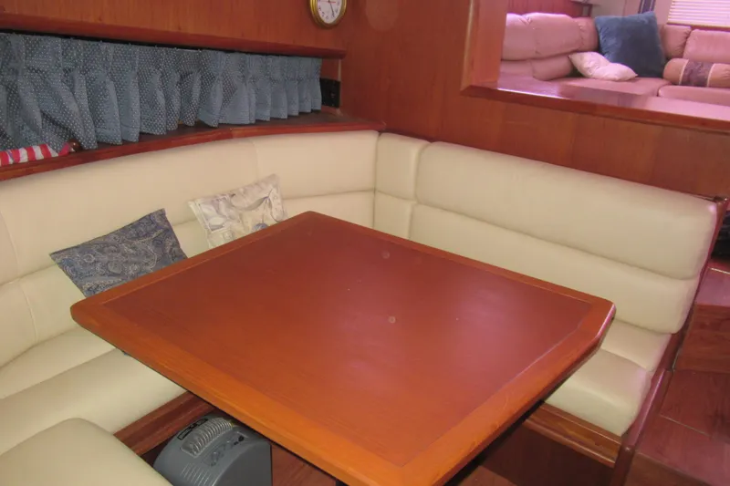 Slide: The Image of Cozy dining area in a 1990 Viking 38 Convertible yacht with cushioned seating and wooden table. - 33