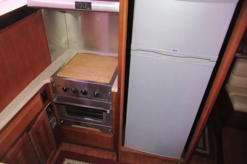 Slide: The Image of Compact kitchen area in a 1990 Viking 38 Convertible yacht with stove and refrigerator. - 34