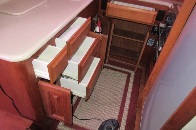 Slide: The Image of Interior of 1990 Viking 38 Convertible yacht with open wooden cabinets and drawers. - 35