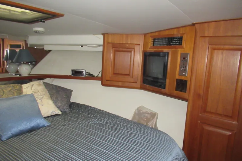 Slide: The Image of Cozy cabin interior of 1990 Viking 38 Convertible yacht with wood paneling and bedding. - 37