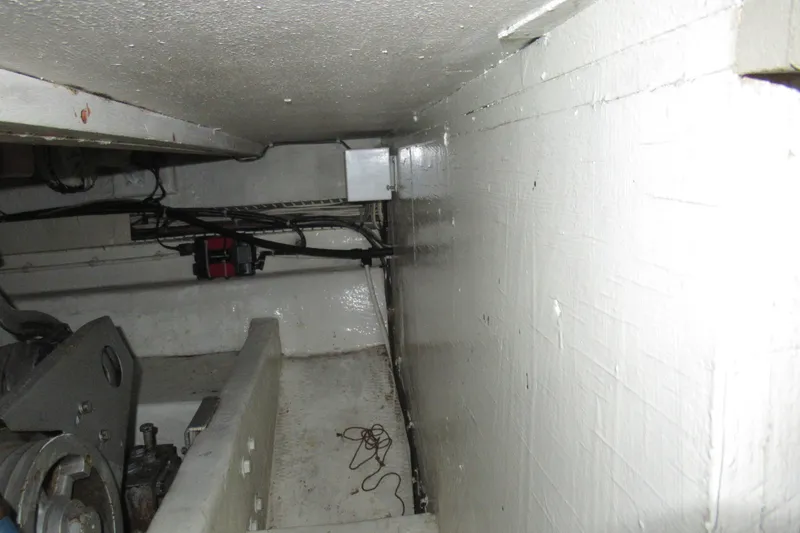 Slide: The Image of Engine room of a 1990 Viking 38 Convertible boat, showcasing mechanical components and wiring. - 44