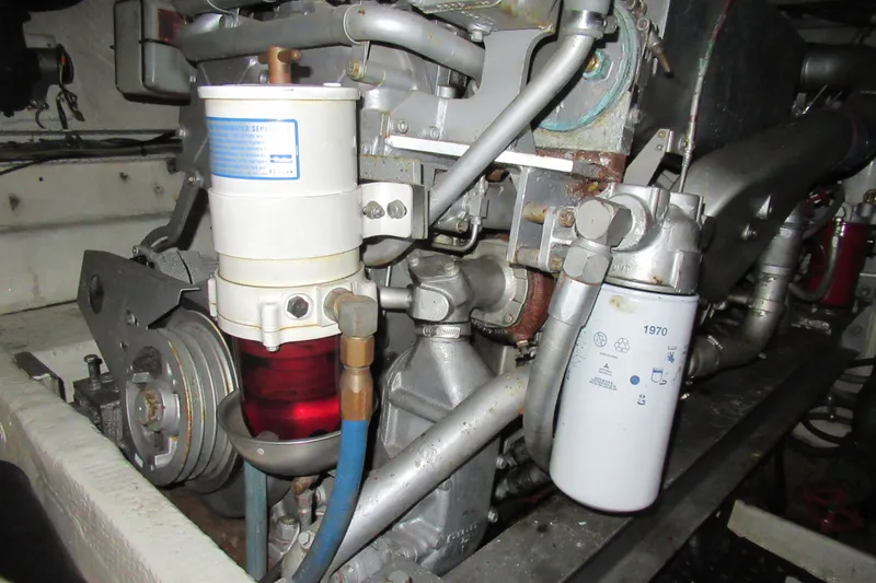 Slide: The Image of Engine components of a 1990 Viking 38 Convertible boat, featuring filters and hoses. - 45