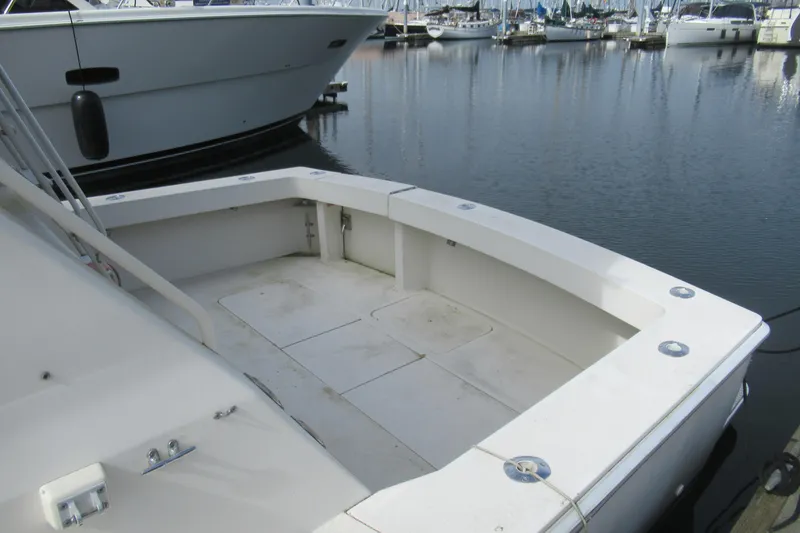Slide: The Image of 1990 Viking 38 Convertible boat docked in a marina, featuring spacious deck area. - 9