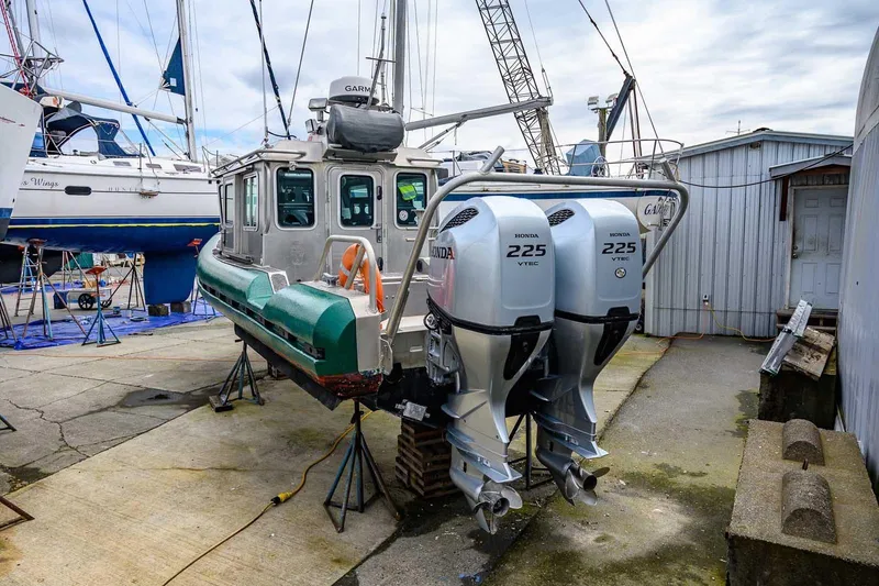 Slide: The Image of 2004 SAFE Boats Defender with twin Honda 225 engines in a boatyard setting. - 10