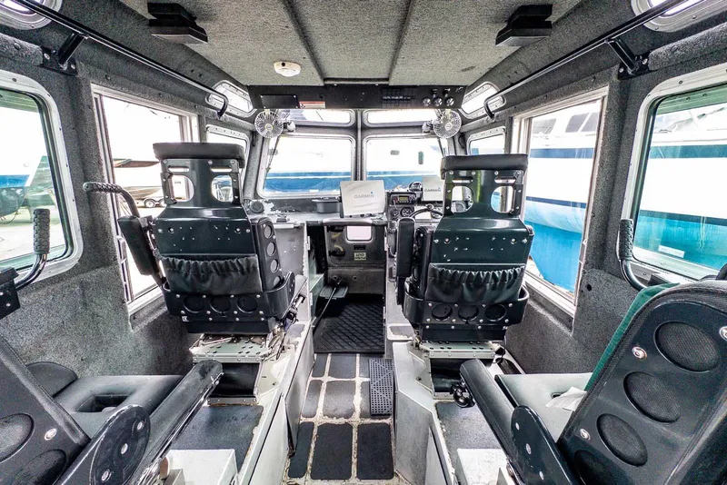 Slide: The Image of Interior of a 2004 SAFE Boats Defender, featuring control panels and seating. - 14