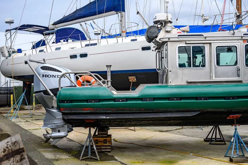 Slide: The Image of 2004 SAFE Boats Defender on dry dock with sailboat in background. - 4