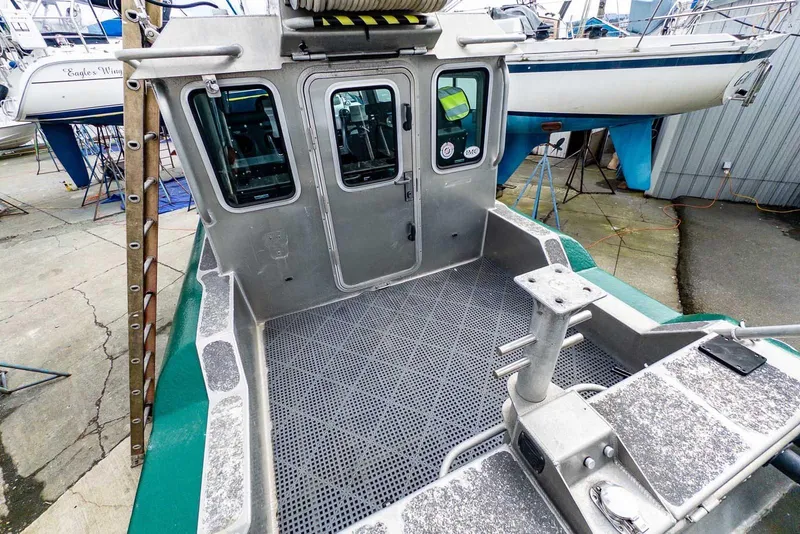 Slide: The Image of 2004 SAFE Boats Defender with metal deck and cabin, docked in a marina. - 6