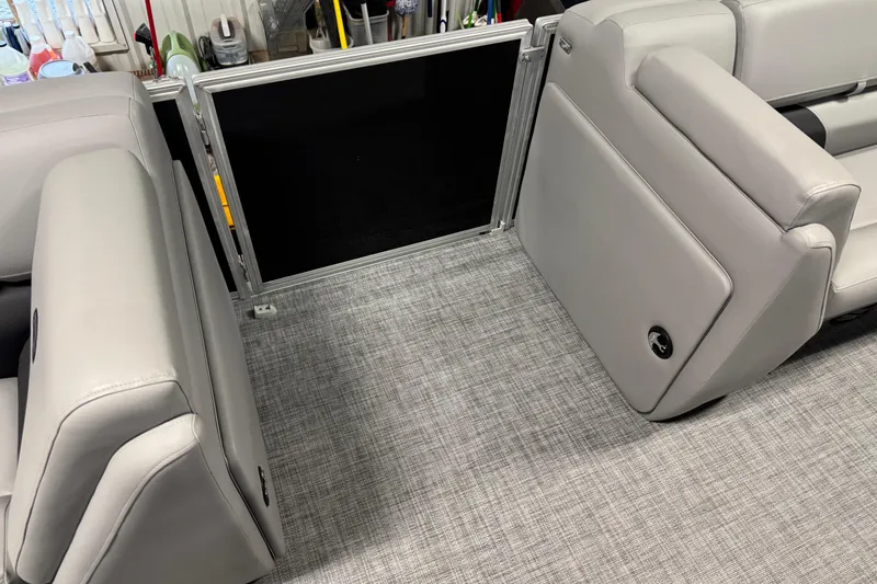 Slide: The Image of 2026 Sun Tracker Party Barge 20 DLX interior seating with gray upholstery and textured flooring. - 13
