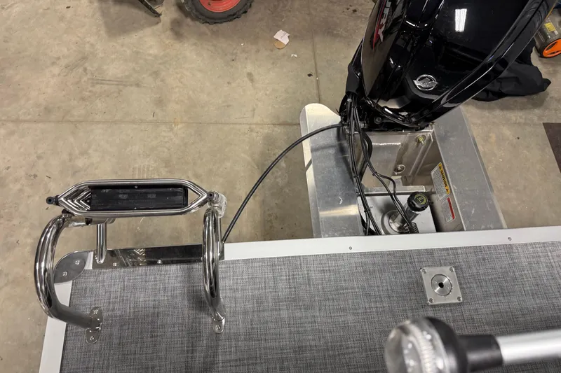 Slide: The Image of 2026 Sun Tracker Party Barge 20 DLX boat motor and ladder detail in a garage setting. - 14