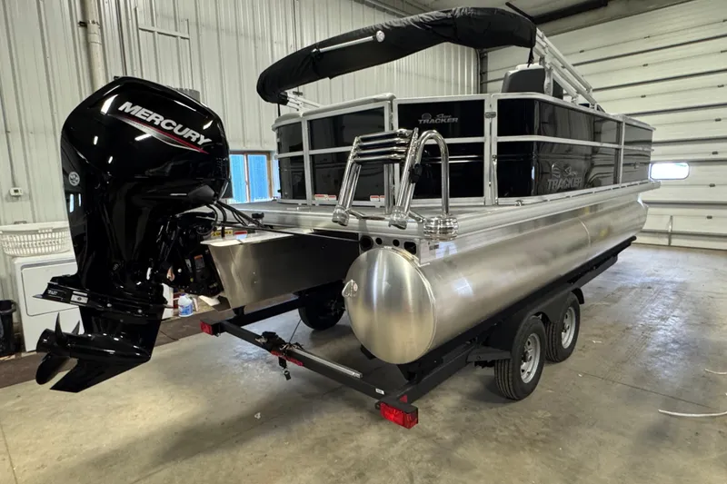 Slide: The Image of 2026 Sun Tracker Party Barge 20 DLX pontoon boat with Mercury engine in a garage. - 3