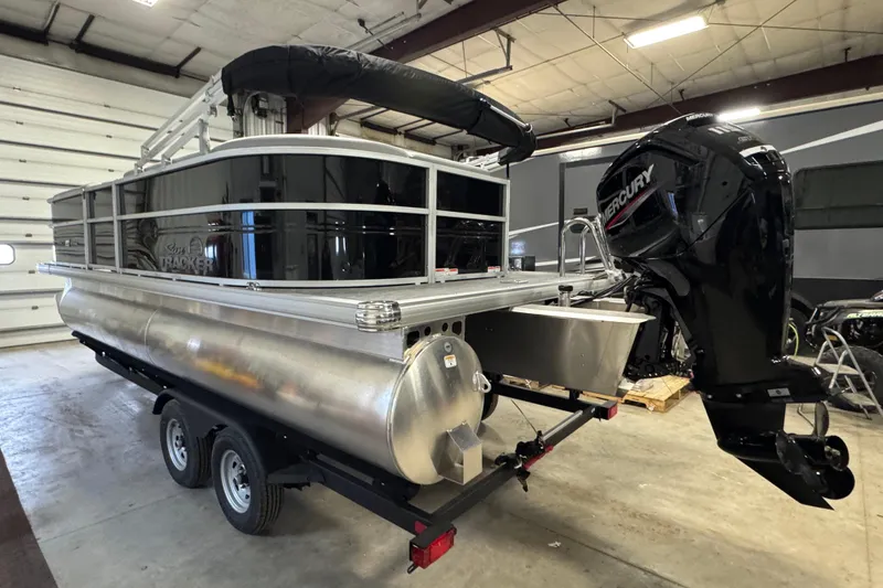 Slide: The Image of 2026 Sun Tracker Party Barge 20 DLX pontoon boat with Mercury engine in a garage. - 4