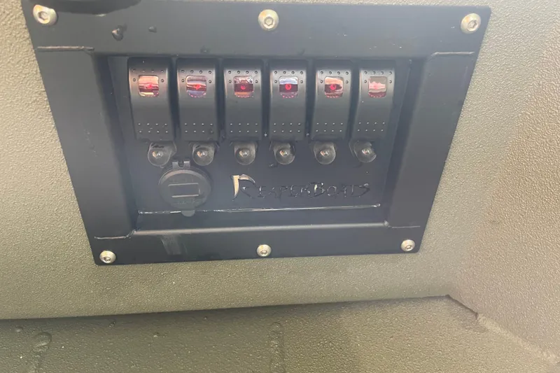 Slide: The Image of Control panel of 2026 Reaper Boats 753 Timber Reaper with switches and logo. - 15