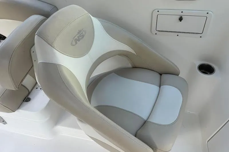 Slide: The Image of 2017 NauticStar 243DC Sport Deck boat seat with beige and white upholstery. - 12
