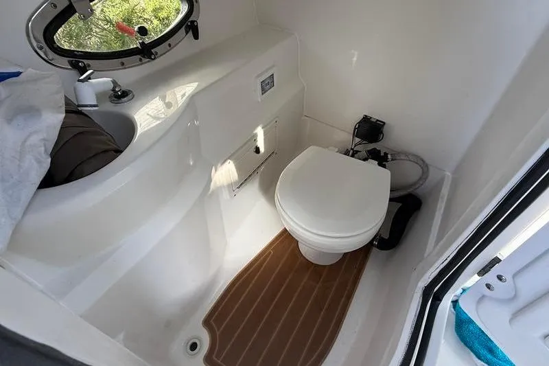 Slide: The Image of 2017 NauticStar 243DC Sport Deck boat bathroom with toilet and sink. - 13