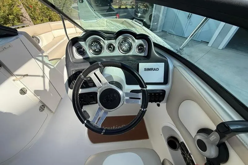 Slide: The Image of 2017 NauticStar 243DC Sport Deck boat dashboard with steering wheel and Simrad display. - 16