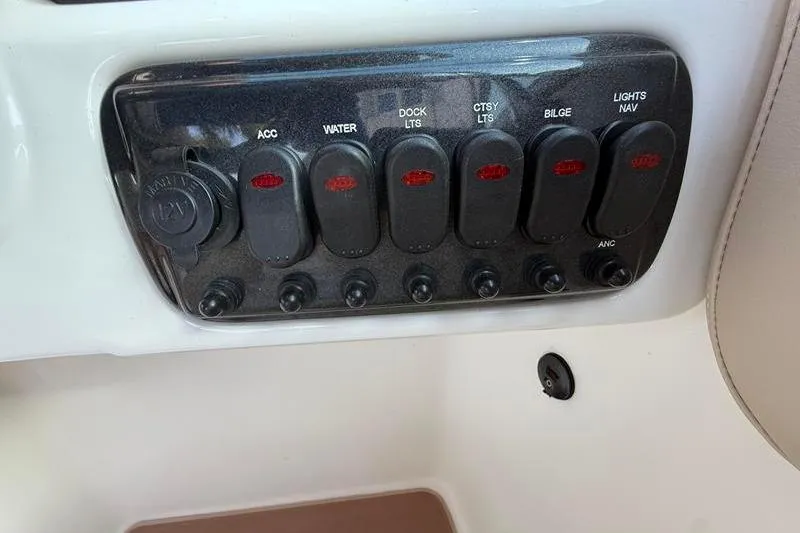 Slide: The Image of Control panel of a 2017 NauticStar 243DC Sport Deck boat with labeled switches. - 17