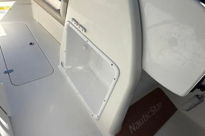 Slide: The Image of 2017 NauticStar 243DC Sport Deck interior with storage compartment and seating area. - 20