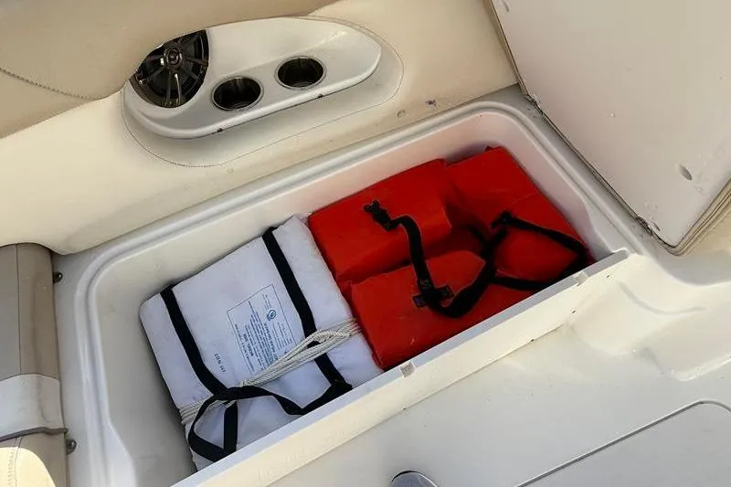 Slide: The Image of Storage compartment with life jackets on a 2017 NauticStar 243DC Sport Deck boat. - 23