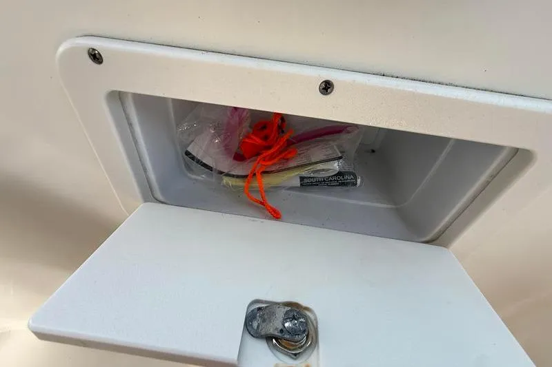Slide: The Image of Storage compartment on 2017 NauticStar 243DC Sport Deck boat with miscellaneous items inside. - 26