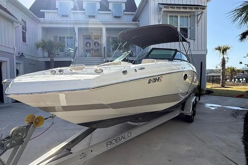 Slide: The Image of 2017 NauticStar 243DC Sport Deck boat on trailer in front of a house. - 4