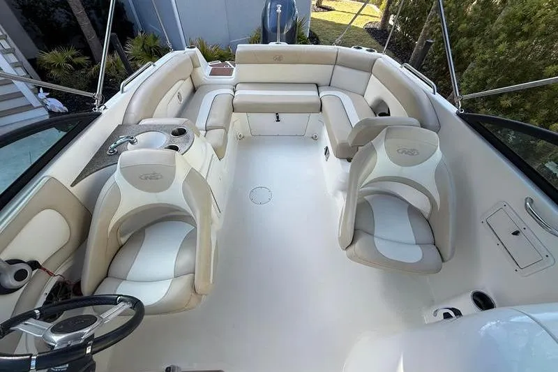 Slide: The Image of 2017 NauticStar 243DC Sport Deck interior with beige seating and steering wheel. - 7
