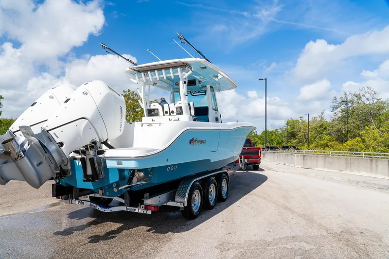 Slide: The Image of 2024 Crevalle 33 CSF boat on trailer, featuring dual Mercury engines, under a clear blue sky. - 11
