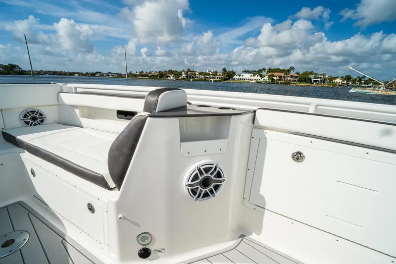 Slide: The Image of 2024 Crevalle 33 CSF boat interior with seating and speaker, overlooking waterfront homes. - 13