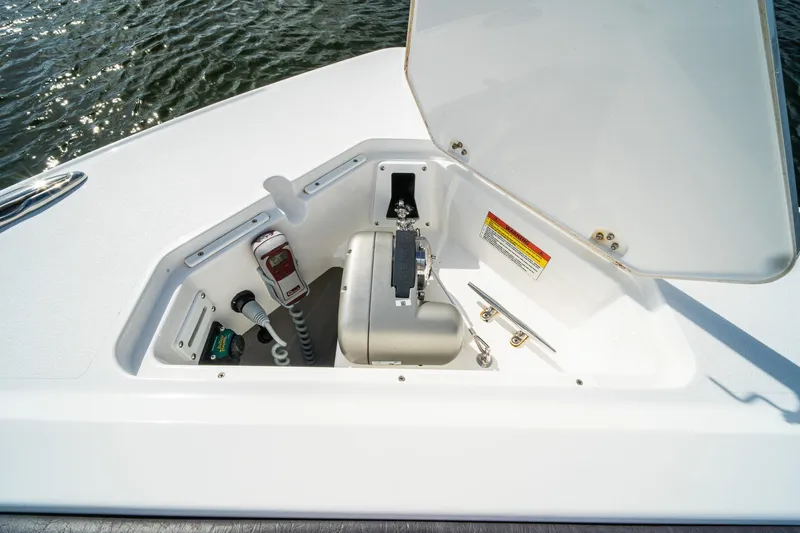 Slide: The Image of 2024 Crevalle 33 CSF boat compartment with open hatch, showcasing interior equipment. - 17
