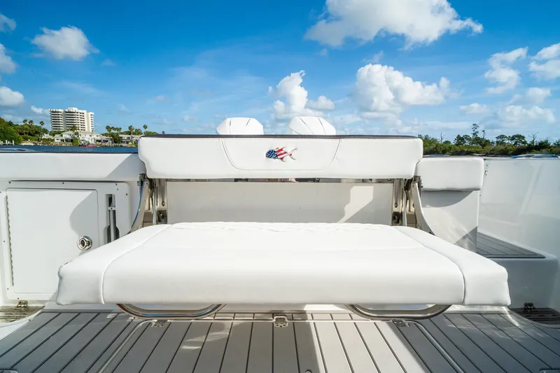 Slide: The Image of 2024 Crevalle 33 CSF boat with white seating, docked under a clear blue sky. - 23