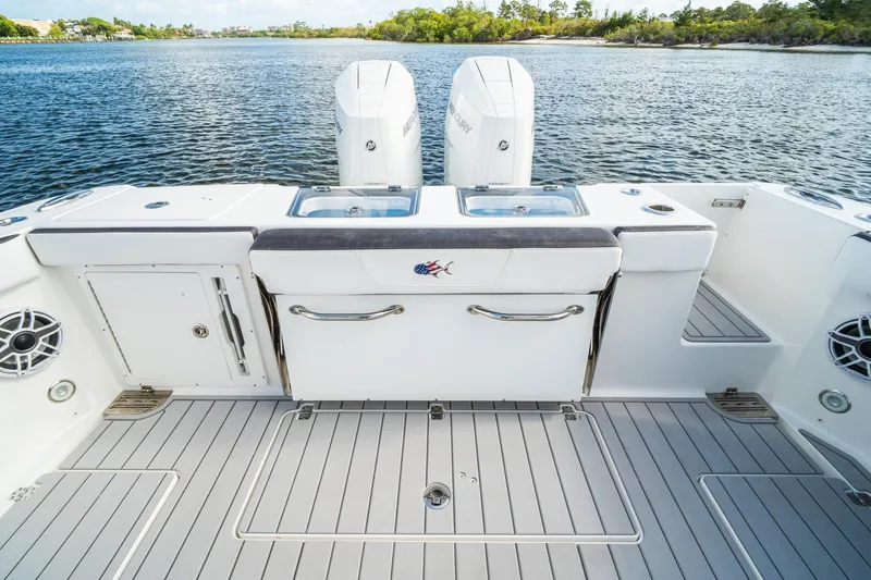 Slide: The Image of 2024 Crevalle 33 CSF boat deck with twin engines on calm water. - 30